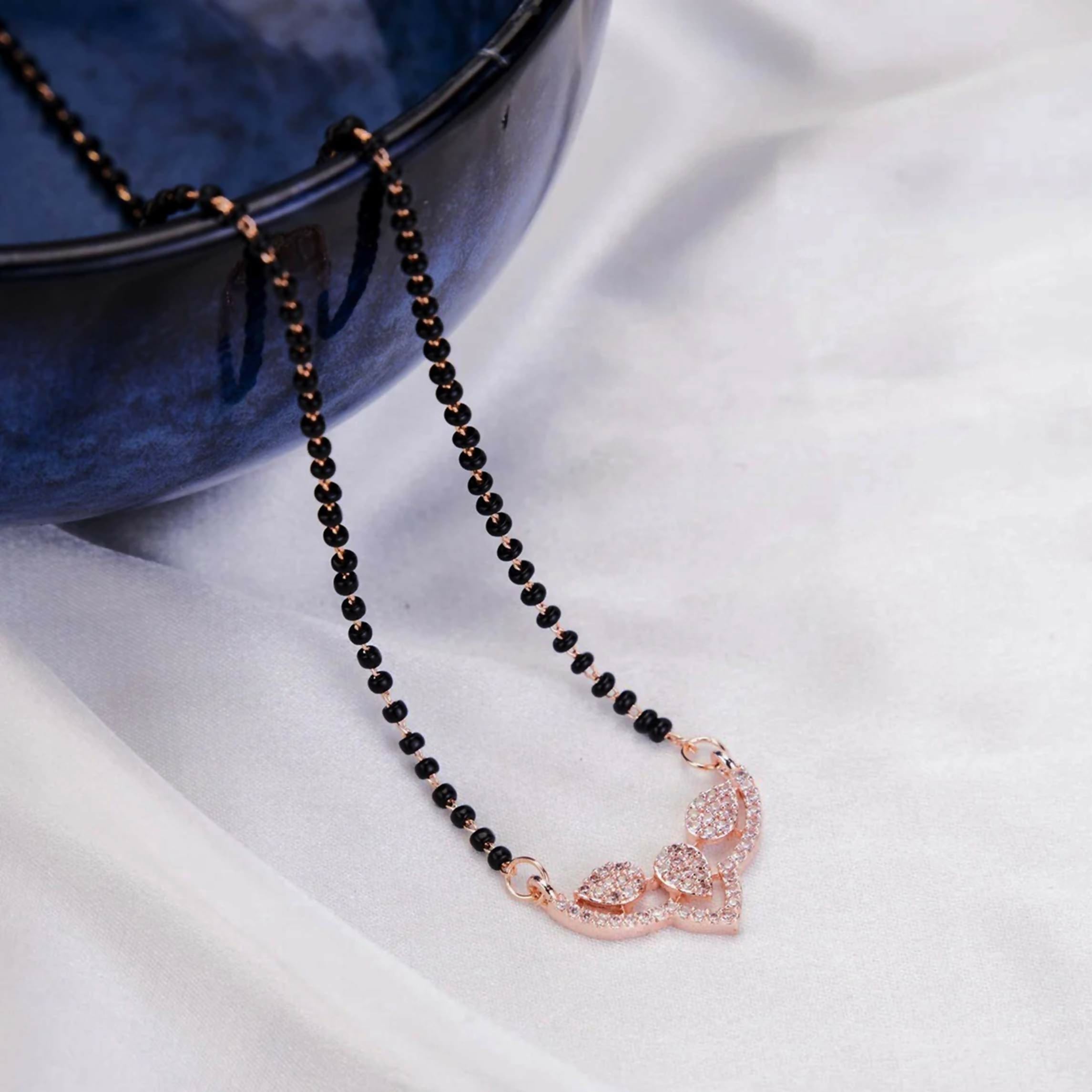 Close up of a Gold Tone AD Mangalsutra necklace featuring intricate traditional design on a white background.