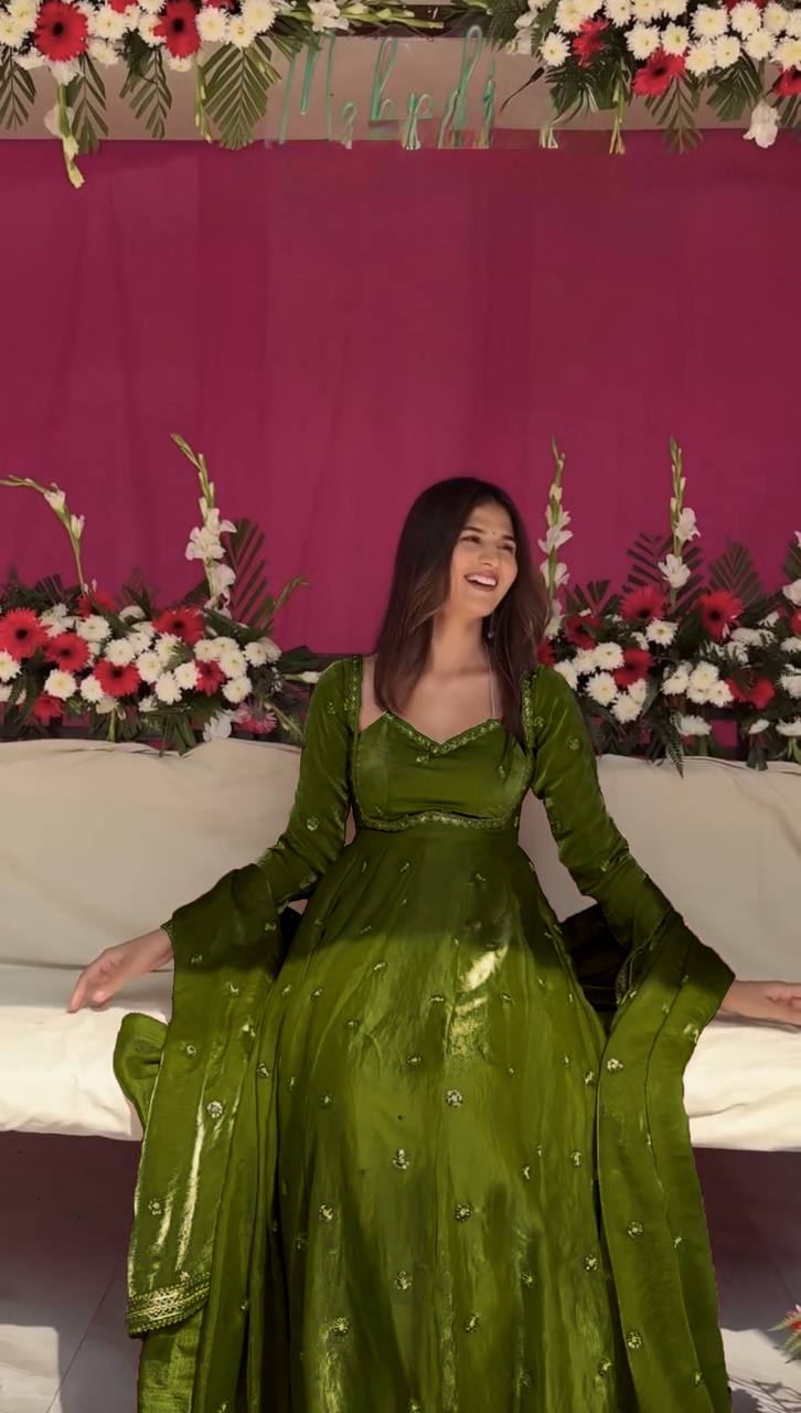 Elegant woman wearing a Mehendi green floor-length silk Anarkali suit with gold sequin details
