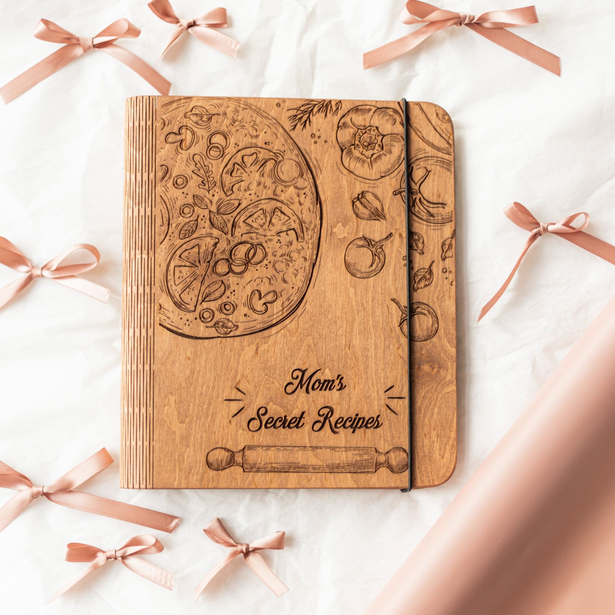 Rustic wooden recipe book cover with pizza-themed engraving.
