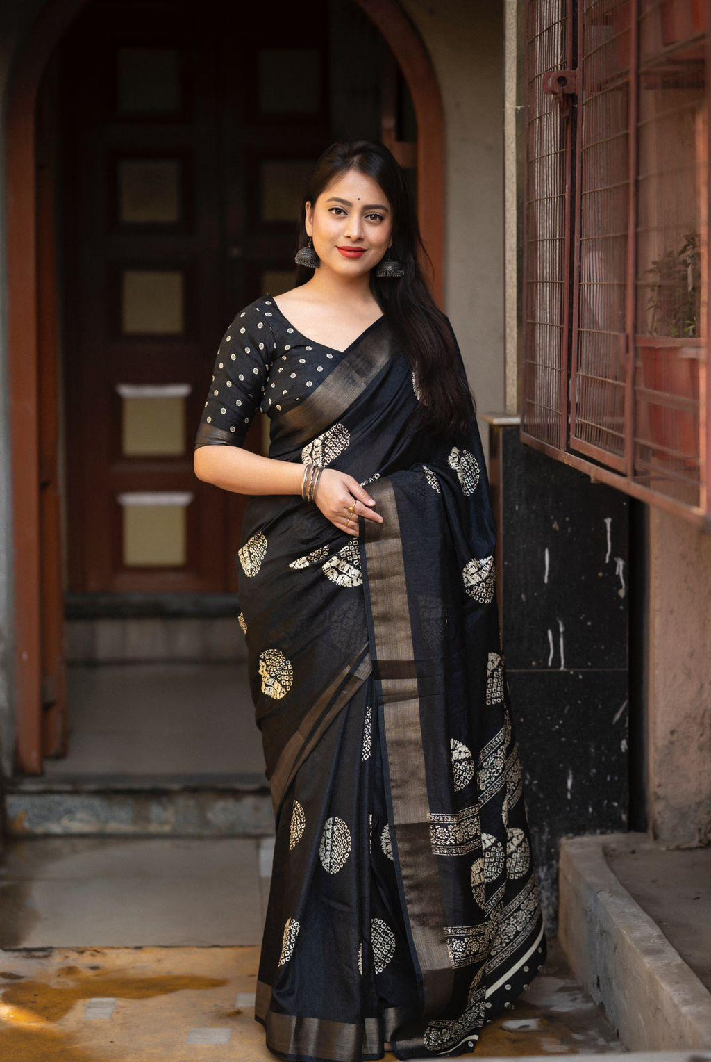 Black cotton crepe saree with traditional batik print and golden zari pattu border