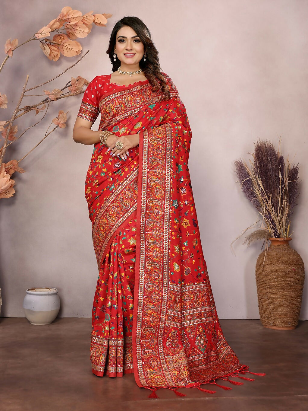 Red Meena Weaves Pashmina Saree featuring traditional patterns and an unstitched blouse piece.