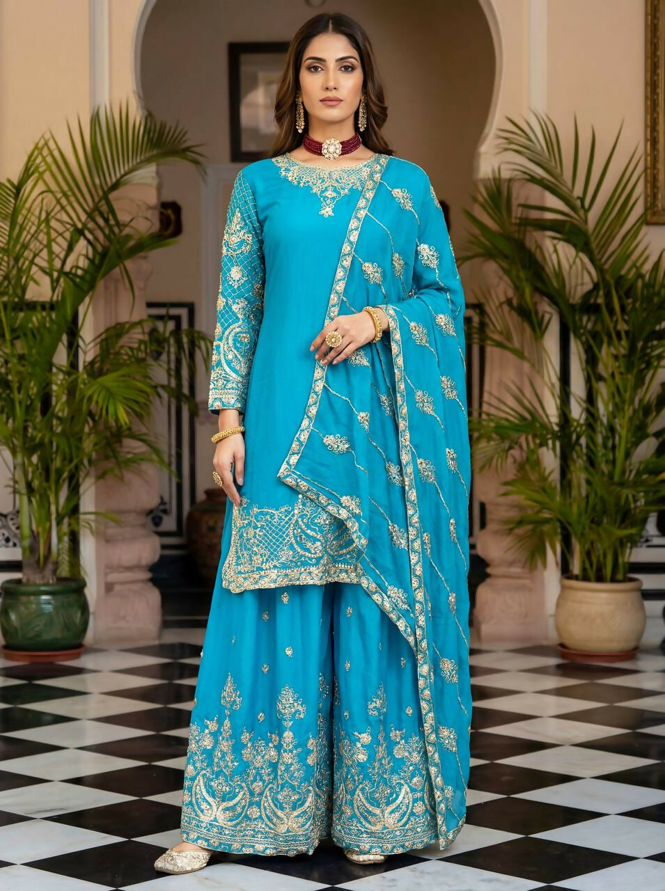 A front view of a sky blue silk embroidered kurti paired with a matching sharara set.