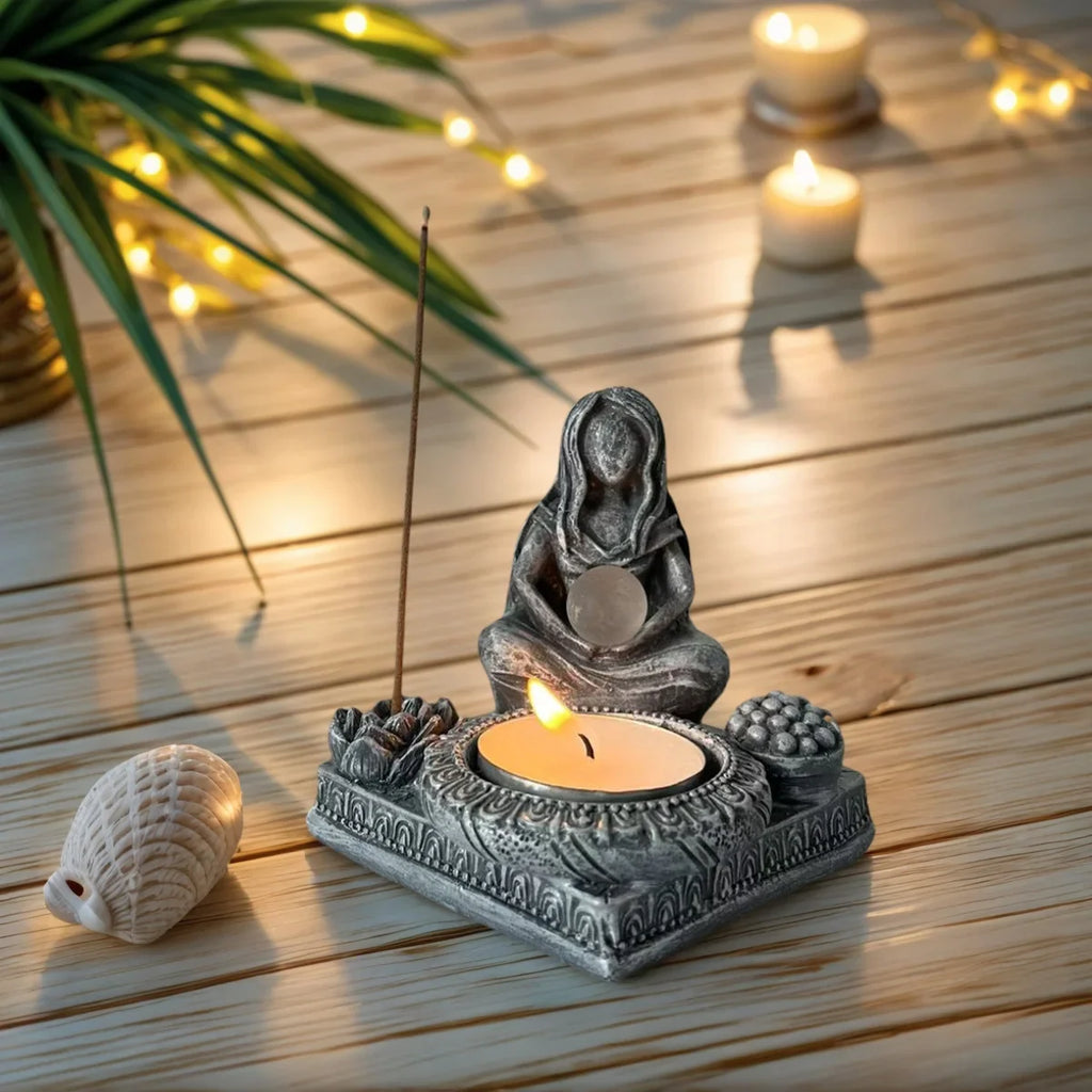 Decorative Moon Goddess resin statue acting as both a candle holder and incense stick holder on a wooden surface.