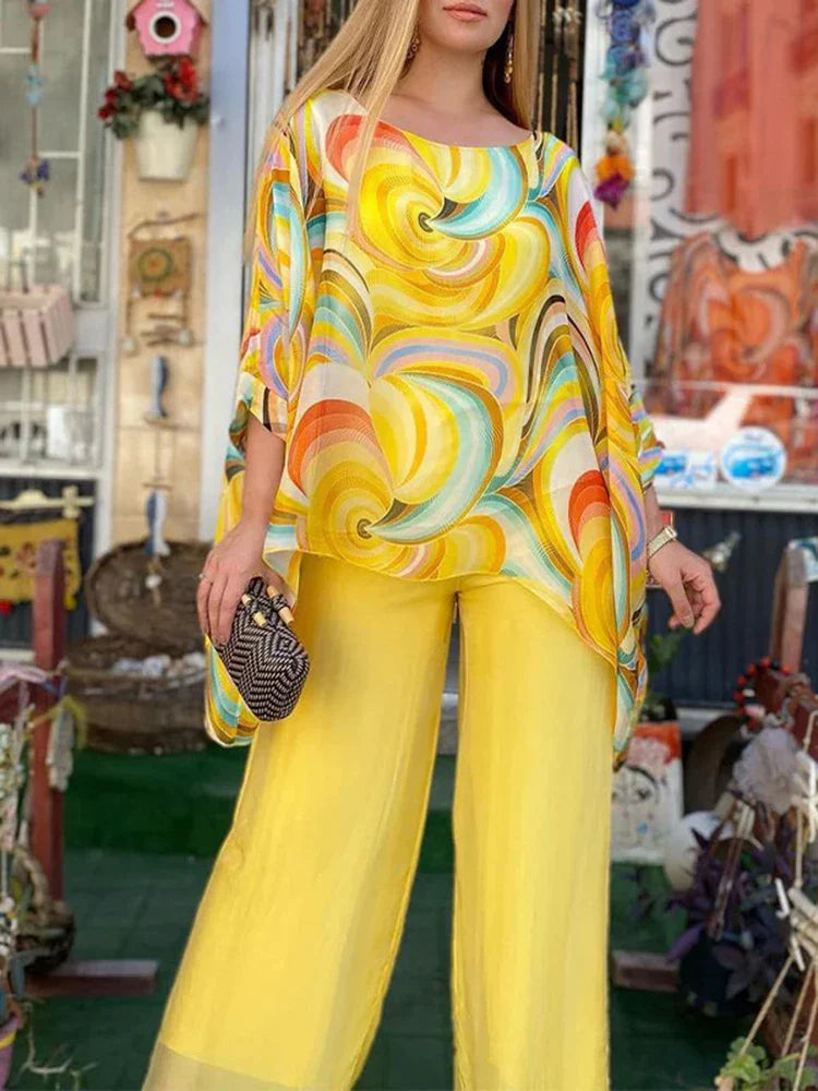A woman wearing a two-piece printed chiffon set with a round neck long sleeve top and wide leg pants.