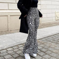 Woman wearing zebra print high waist wide leg pants with white sneakers