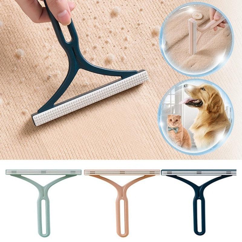 Minimalist double-sided lint remover in sage green on a clean, modern surface.
