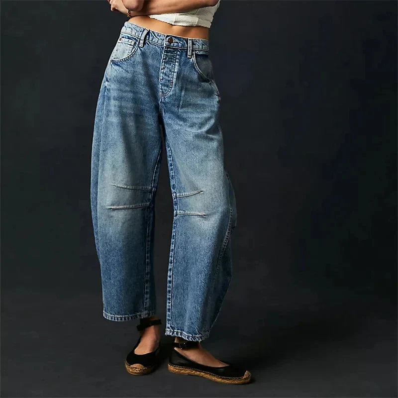 Model wearing blue mid-rise wide leg baggy jeans with a casual top