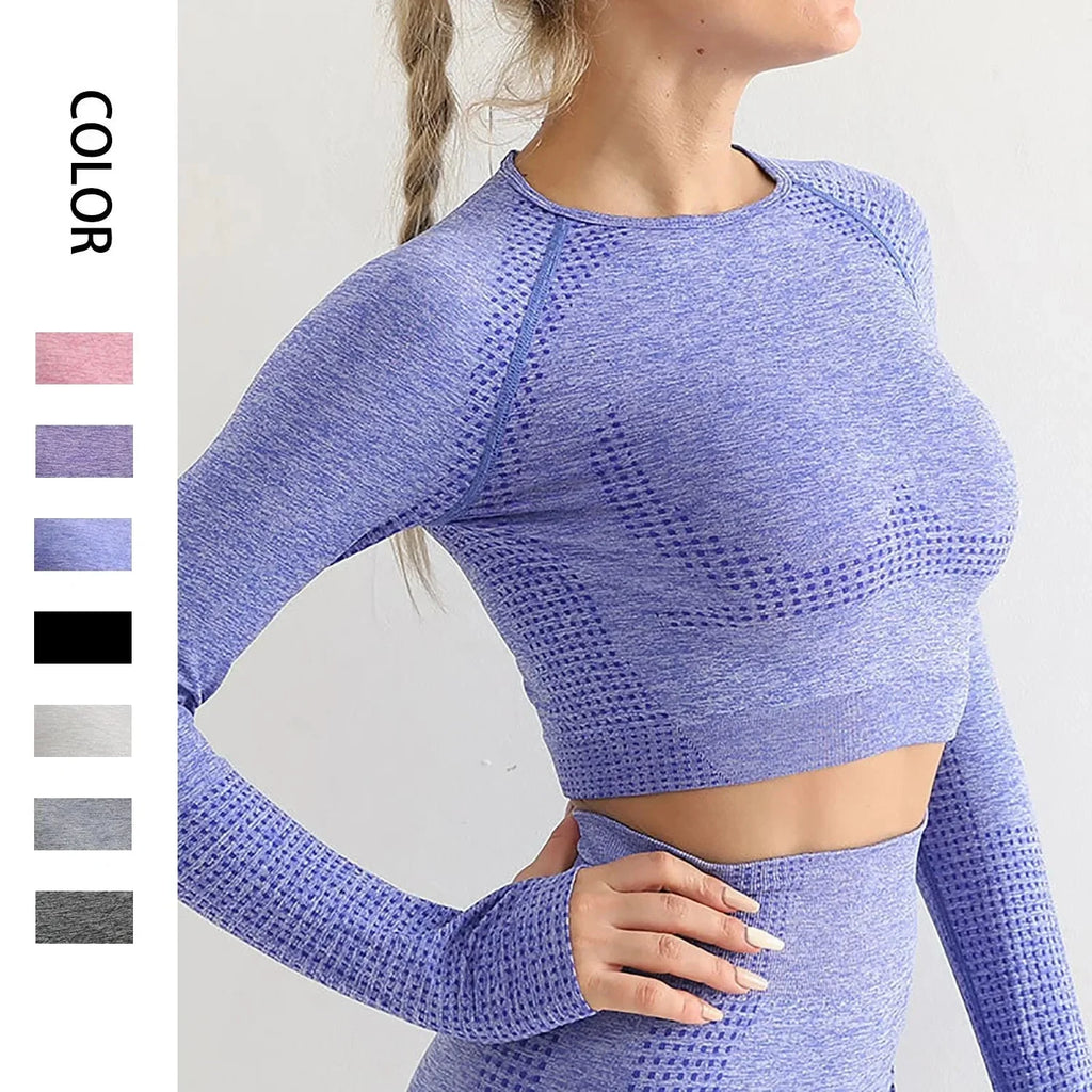 A woman wearing a seamless long sleeve blue yoga crop top with textured details.
