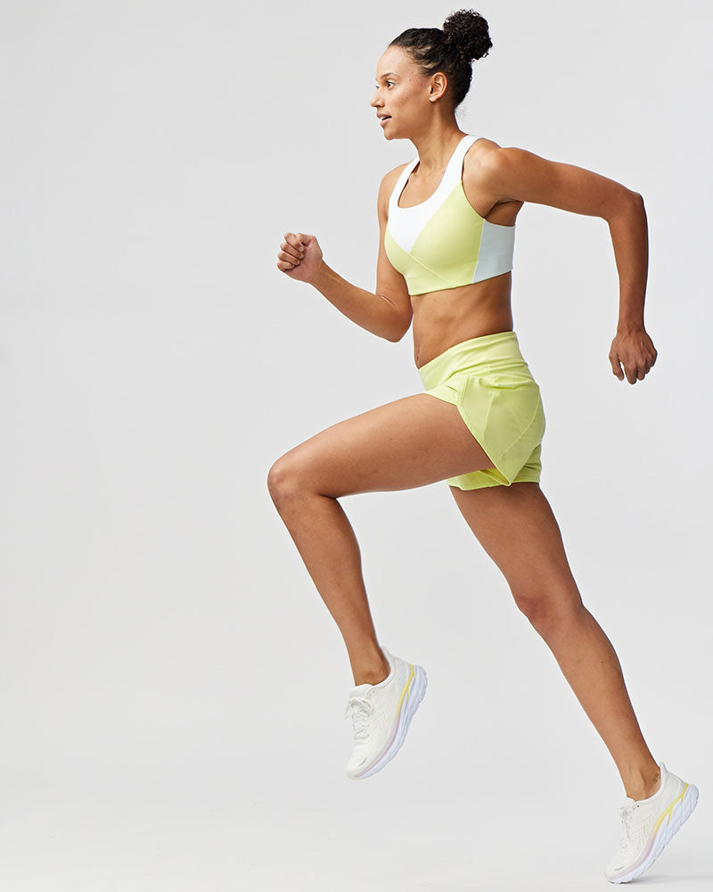 A woman wearing black Sheva high rise running shorts while running outdoors