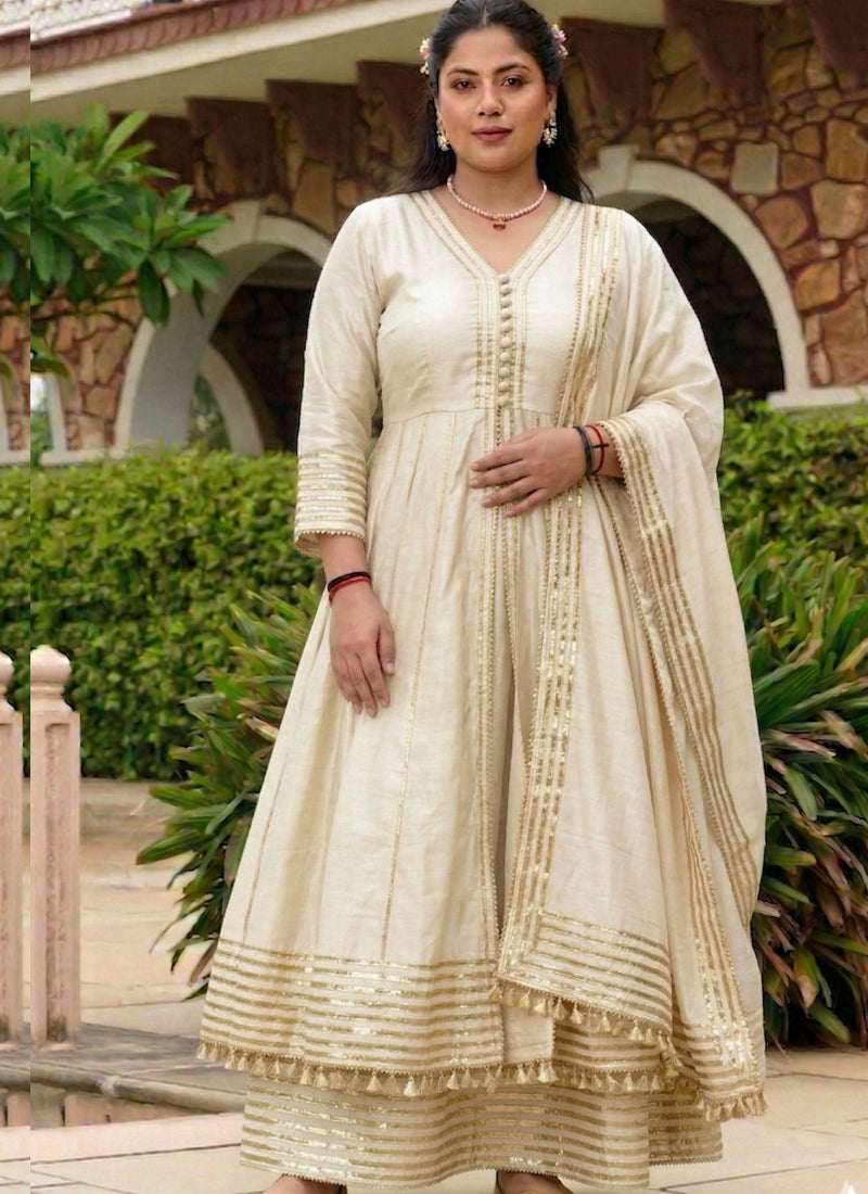 Woman wearing a cream cotton palazzo suit with gold gota accents and a relaxed A-line silhouette