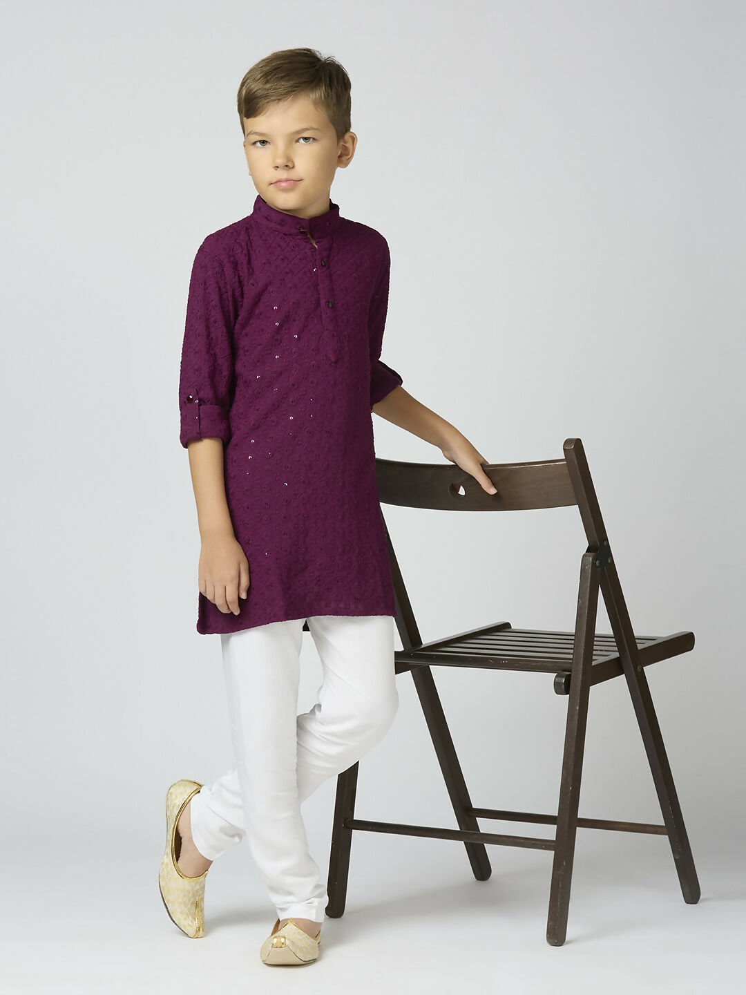 A young boy wearing a wine-colored cotton kurta and pyjama set featuring elegant sequin embroidery.