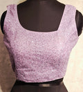 Lilac readymade blouse with all-over silver sequins and asymmetrical neckline.