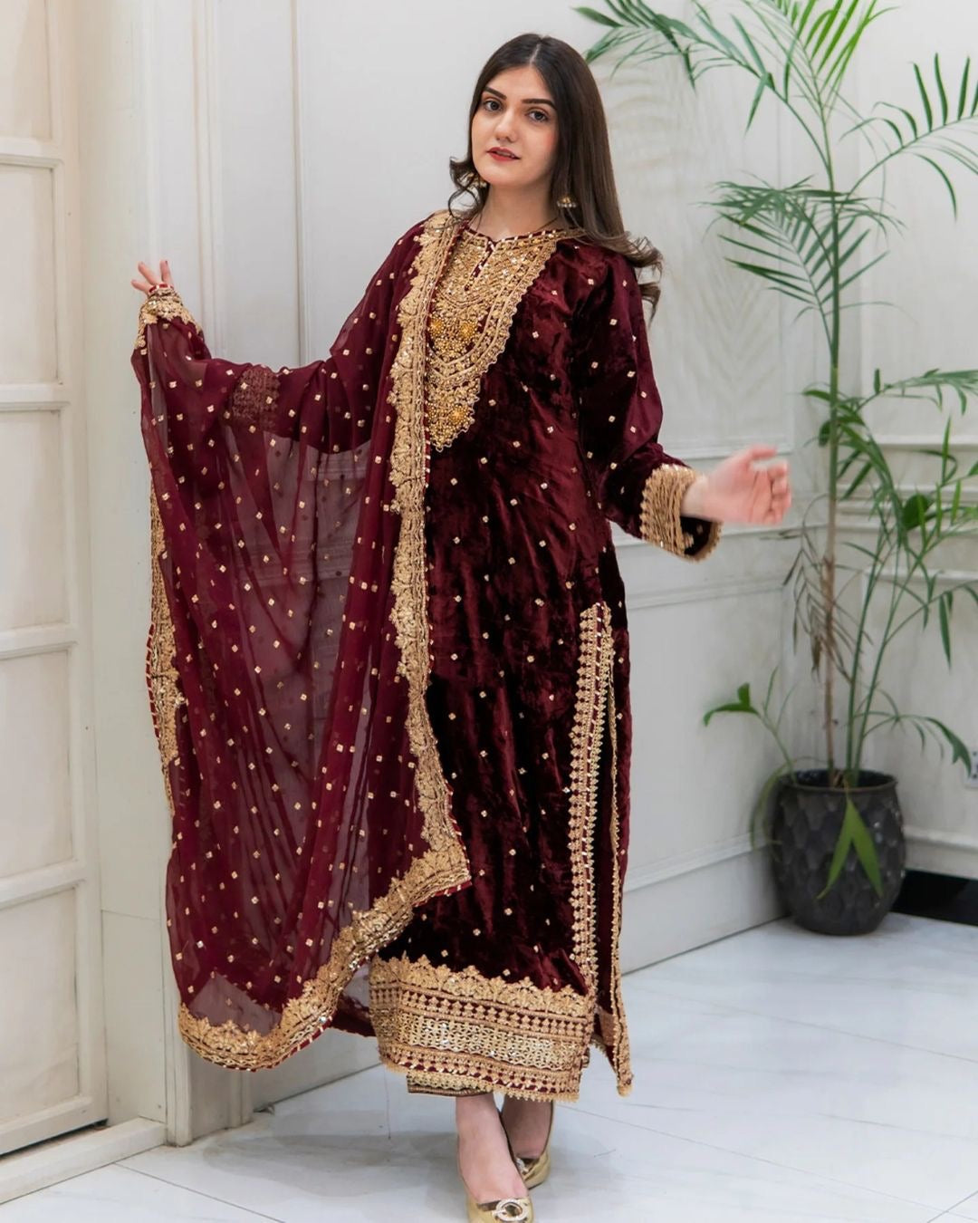 Maroon viscose velvet salwar suit featuring intricate sequins embroidery and moti work on the neck.