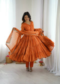 An orange Mal Chanderi silk Anarkali gown with intricate real mirror and handwork details.