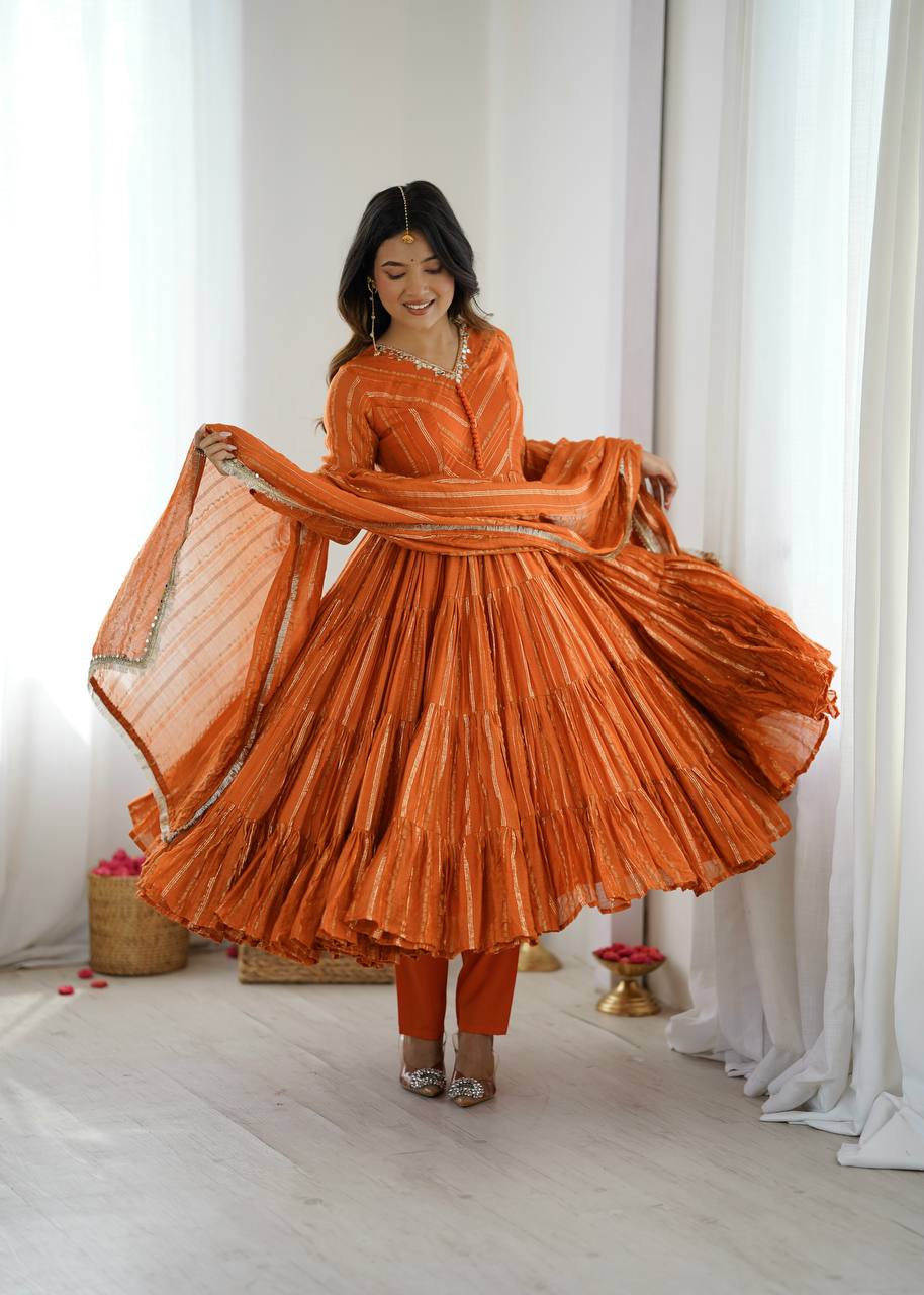 An orange Mal Chanderi silk Anarkali gown with intricate real mirror and handwork details.