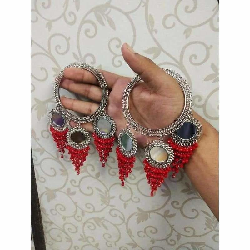 Silver-tone designer bangle with red pearls and hanging mirror latkan accents.