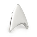 Close-up of a silver Star Trek Delta Shield lapel pin on a plain white background
