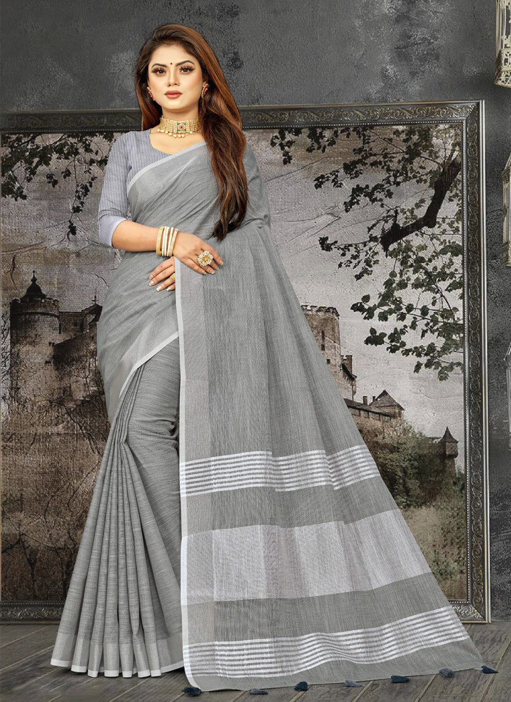 Dark grey linen saree with contrast zari border and decorative tassels