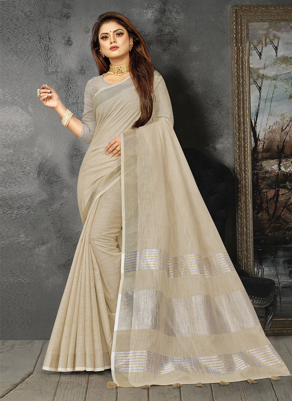 Cream linen saree with a distinct contrast zari border and decorative tassels