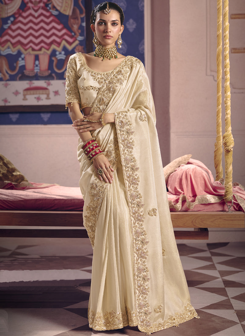 Cream silk saree featuring heavy lace border embroidery for wedding wear