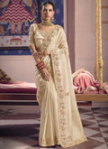Cream silk saree featuring heavy lace border embroidery for wedding wear