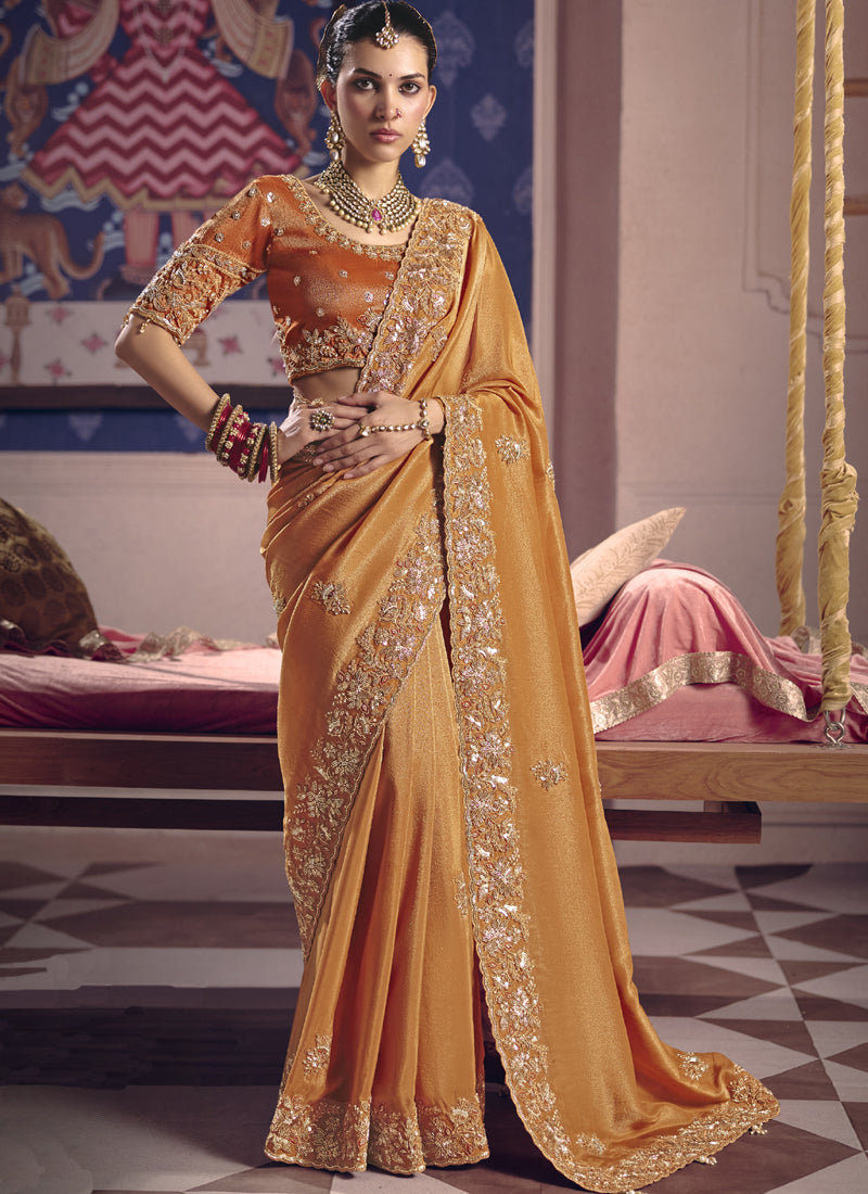 Vibrant orange silk saree with heavy lace border and embroidery
