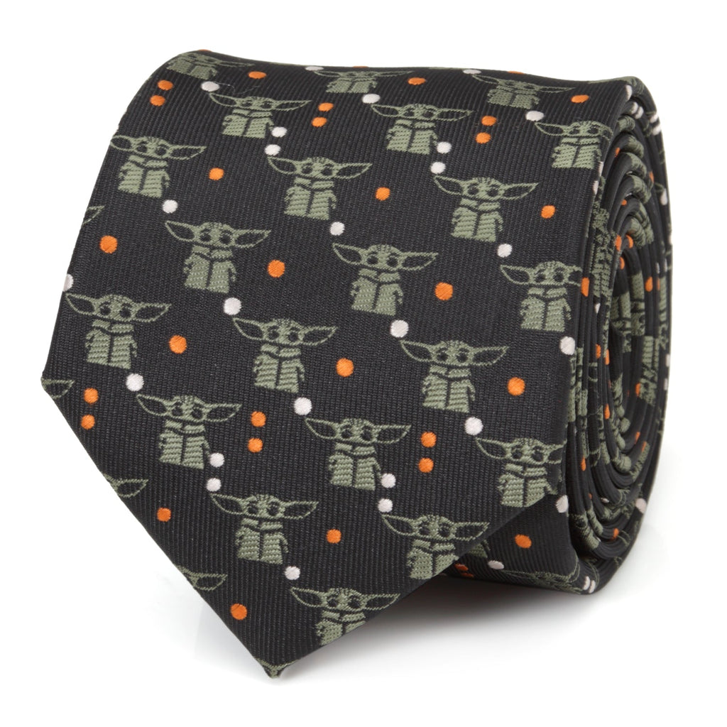 Close up of a black Star Wars necktie featuring sage green Grogu character patterns and orange and white dots.