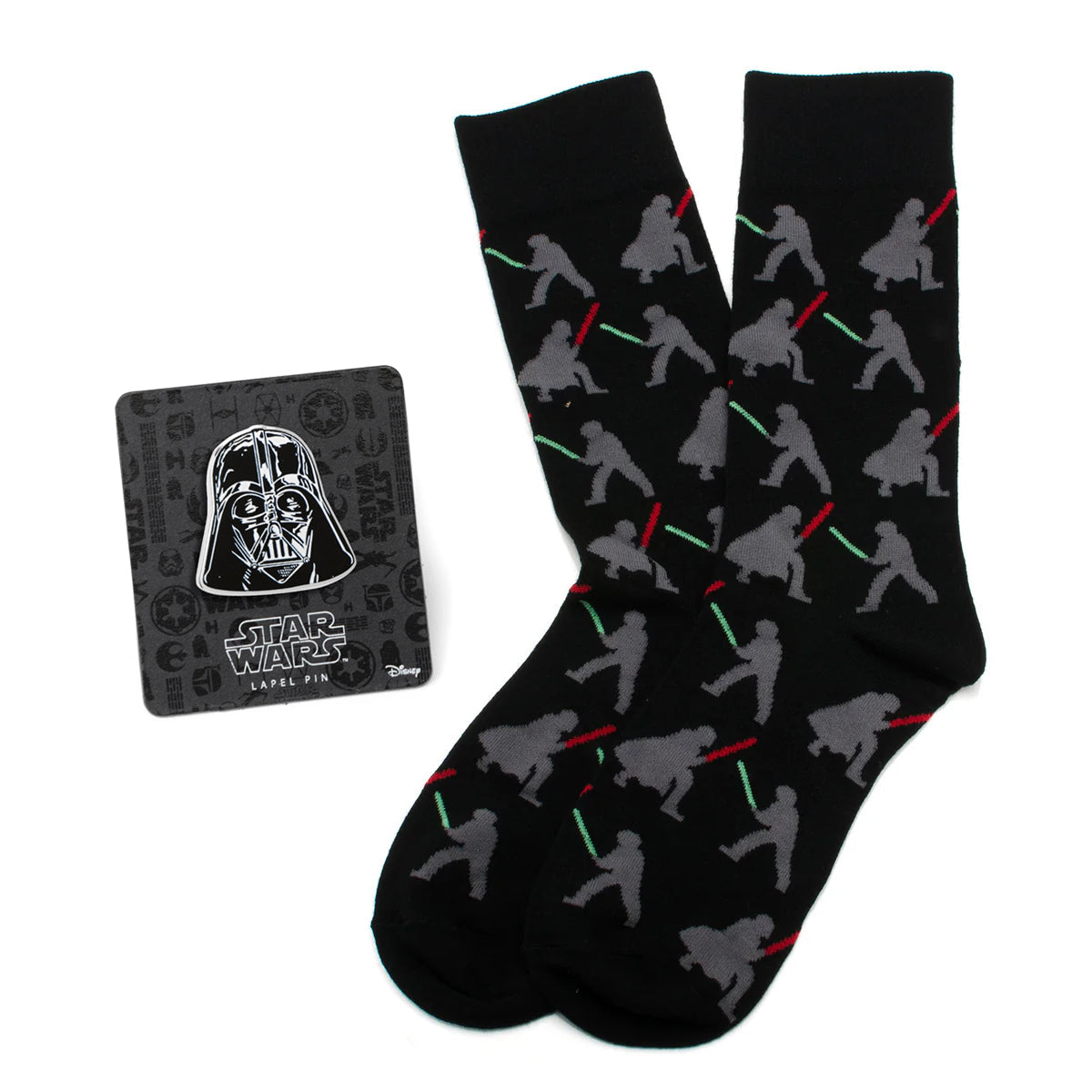 Black crew socks featuring a pattern of Darth Vader and Luke Skywalker dueling with lightsabers, next to a Darth Vader lapel pin.