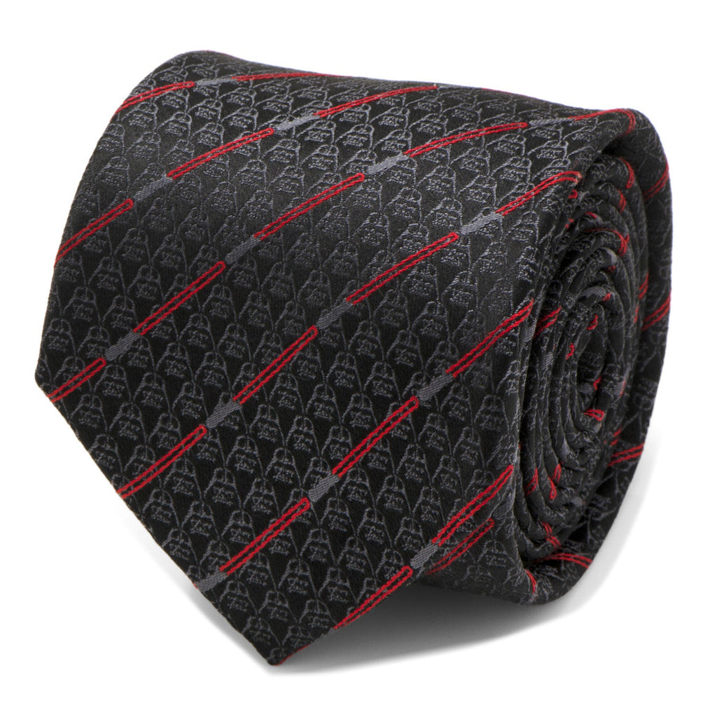 Close-up view of a black silk necktie featuring a repeating Darth Vader helmet pattern and diagonal red lightsaber stripes.