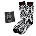 A pair of white crew socks with a repeating Darth Vader helmet pattern and a matching Darth Vader metal lapel pin.