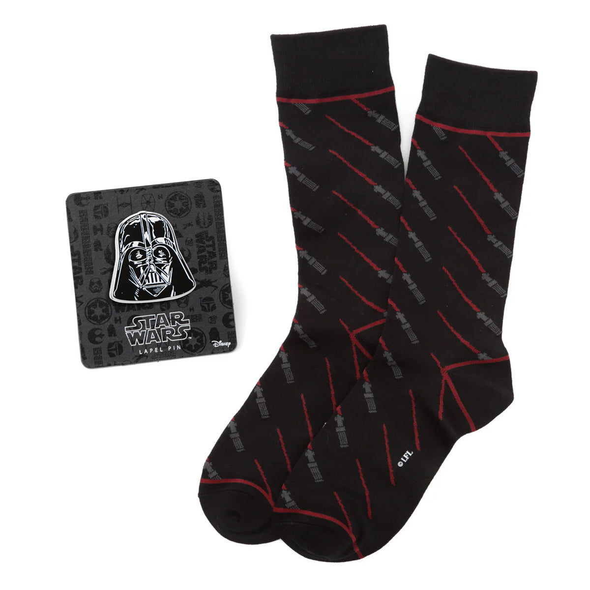 A pair of black crew socks with a red and grey lightsaber pattern next to a Star Wars Darth Vader lapel pin.