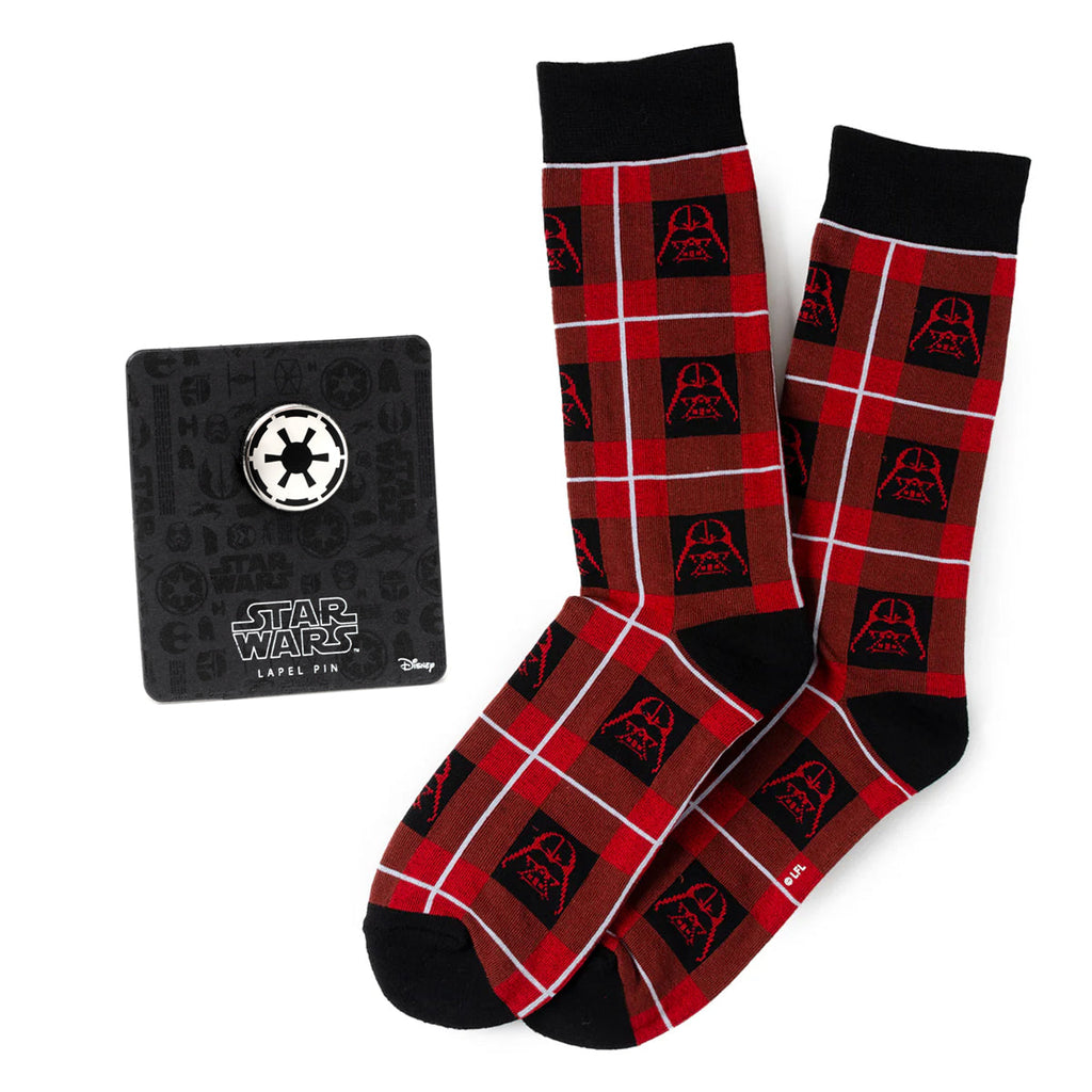 A pair of red and black plaid crew socks with Darth Vader helmet print next to an Imperial crest lapel pin on a display card.