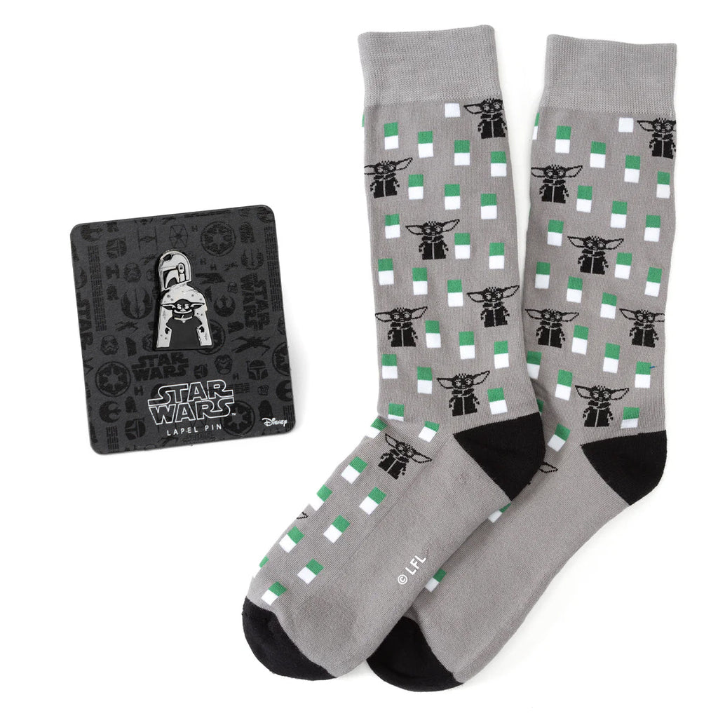A pair of gray crew socks featuring a pattern of Grogu and a matching Star Wars The Mandalorian metal lapel pin.