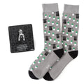 A pair of gray crew socks featuring a pattern of Grogu and a matching Star Wars The Mandalorian metal lapel pin.