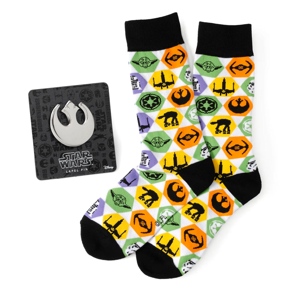 A pair of white, green, and orange patterned Star Wars crew socks next to a silver Rebel Alliance lapel pin on a display card.