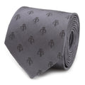 A close-up view of a slate gray silk tie featuring a repeating dark gray Mandalorian Mythosaur skull pattern.