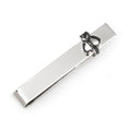 Silver tone Star Wars Mandalorian Mythosaur tie bar on a grey patterned tie.