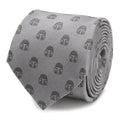 Close up of a pale gray silk necktie featuring a repeating pattern of dark gray Mandalorian helmet icons.