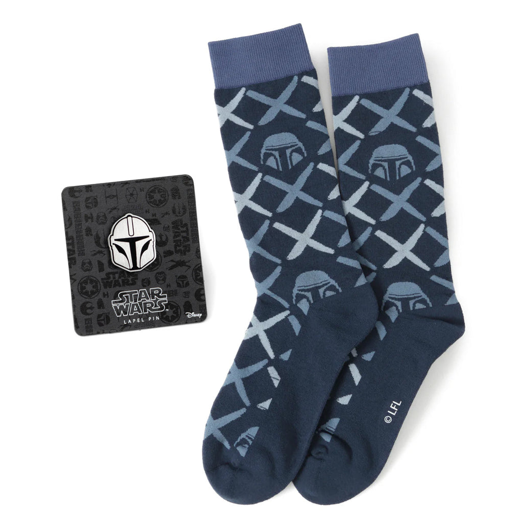 The Mandalorian navy dress socks with helmet pattern displayed next to a matching Mandalorian helmet lapel pin on a black Star Wars branded card.