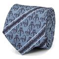 A close-up of a blue and navy Star Wars necktie featuring Mandalorian helmet and Mythosaur skull patterns, displayed tied on a dress shirt.