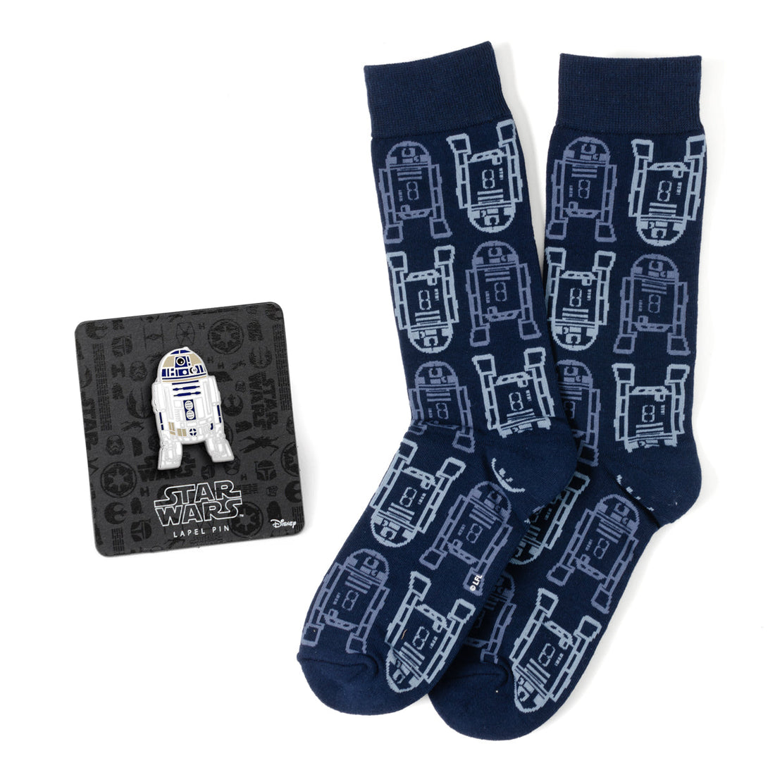 A pair of navy blue Star Wars crew socks with a repeating R2-D2 pattern next to a matching R2-D2 lapel pin.