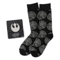 A black pair of Star Wars Millennium Falcon socks next to a Rebel Alliance metal lapel pin on its display card.