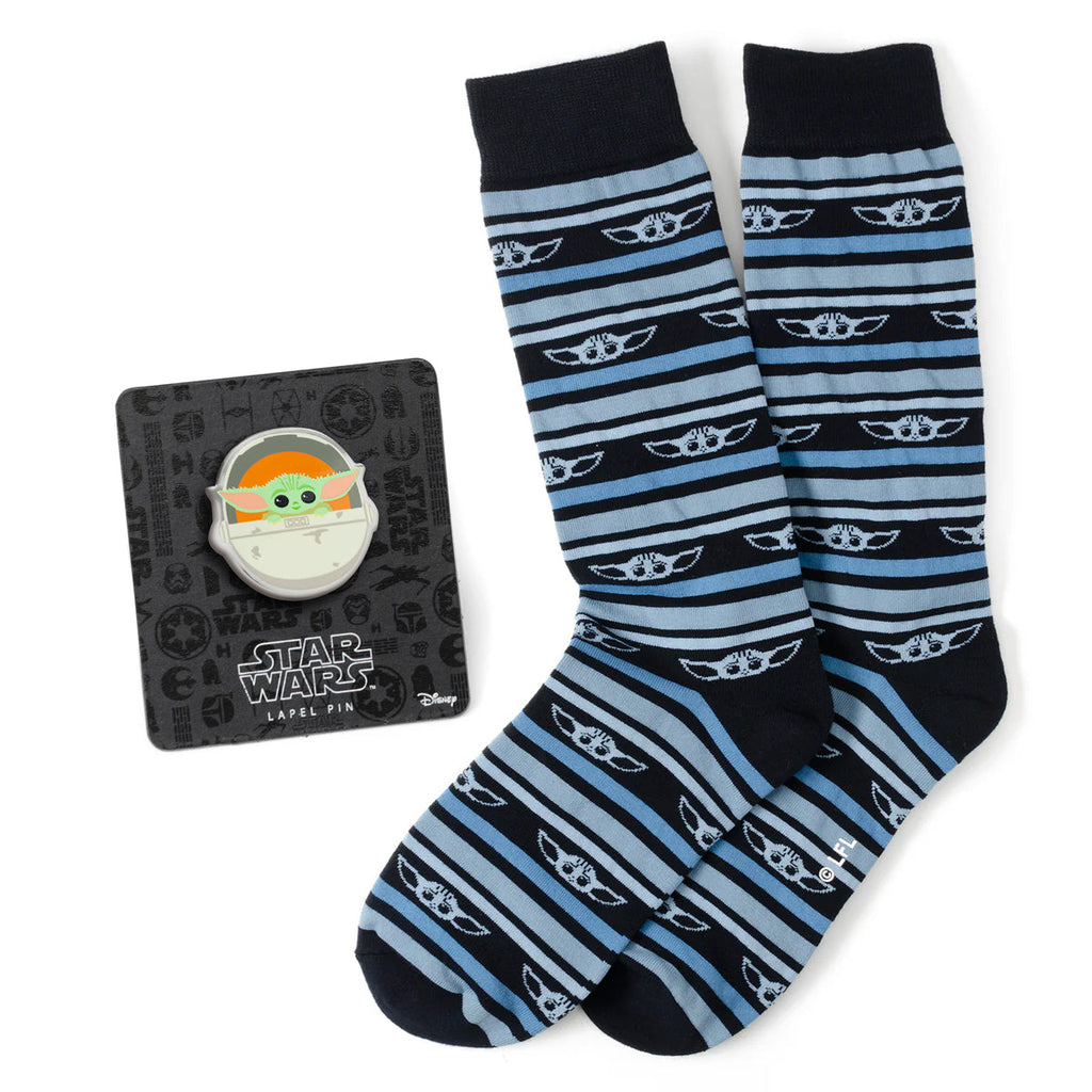 A pair of navy blue striped crew socks with Grogu icons next to a Star Wars themed Grogu lapel pin.