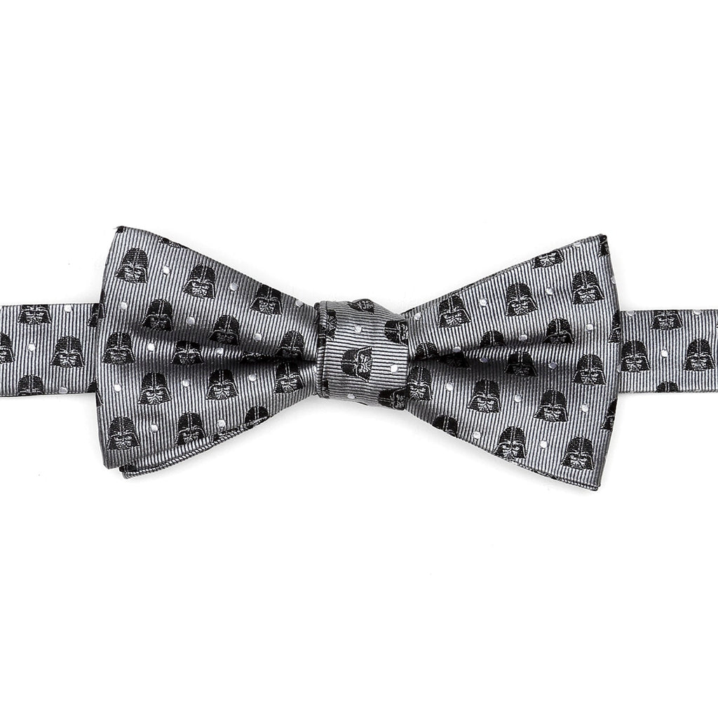 A pre-tied gray bow tie featuring a repeating pattern of Darth Vader helmets and white polka dots on a white dress shirt background.