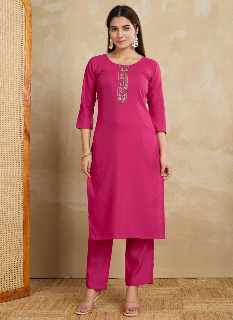 A woman wearing a pink printed cotton blend kurta and matching pants set.