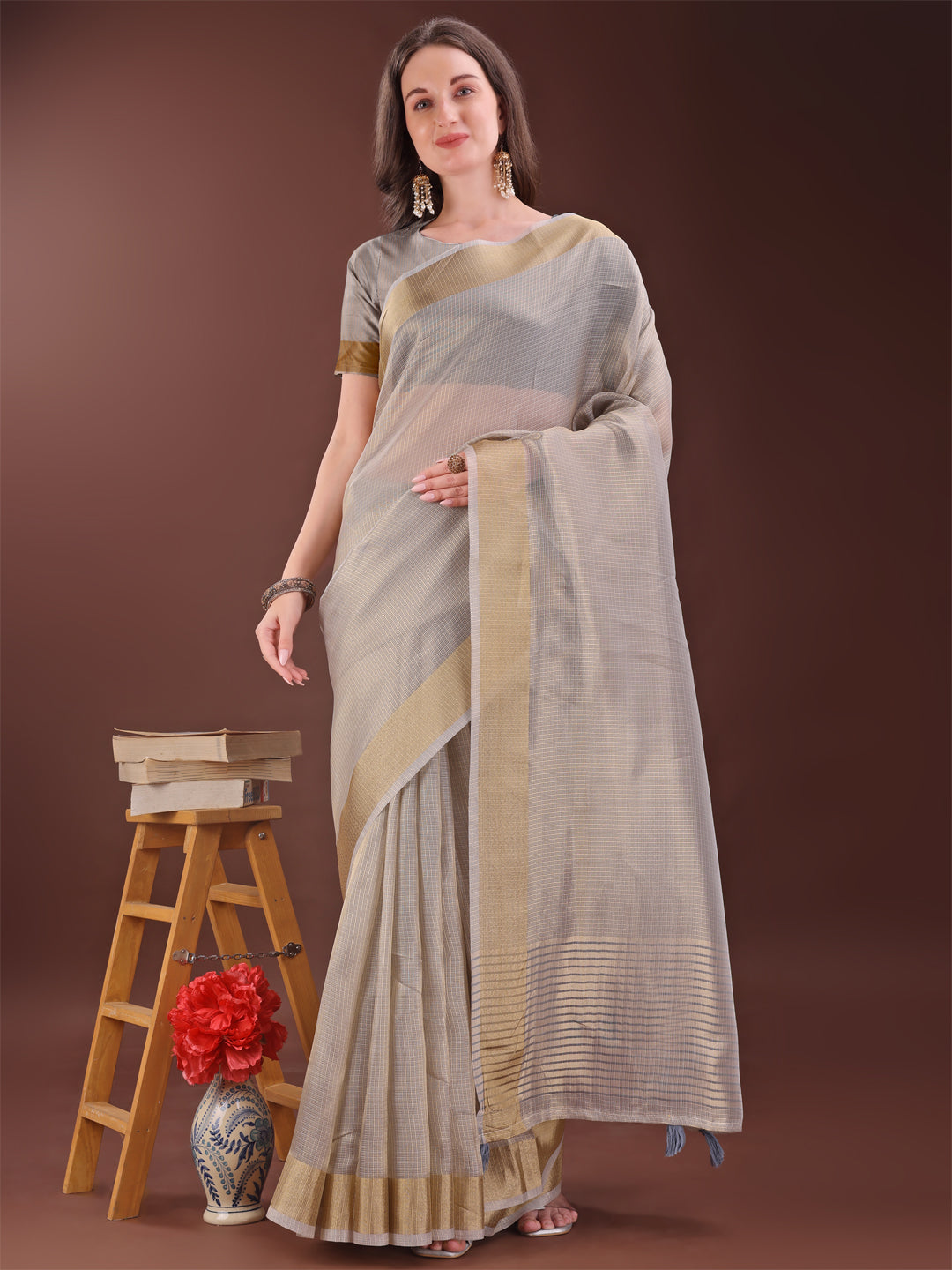 Elegant brown organza saree with a golden zari border and matching blouse piece