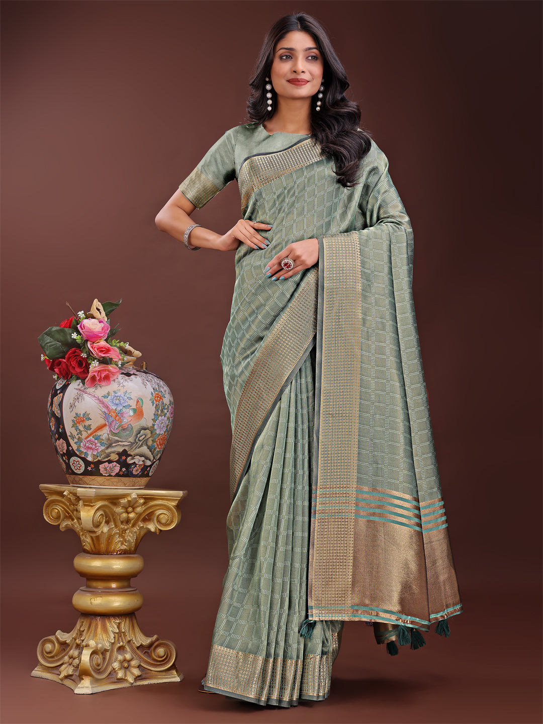 Light green organza saree with a detailed golden zari border and matching blouse