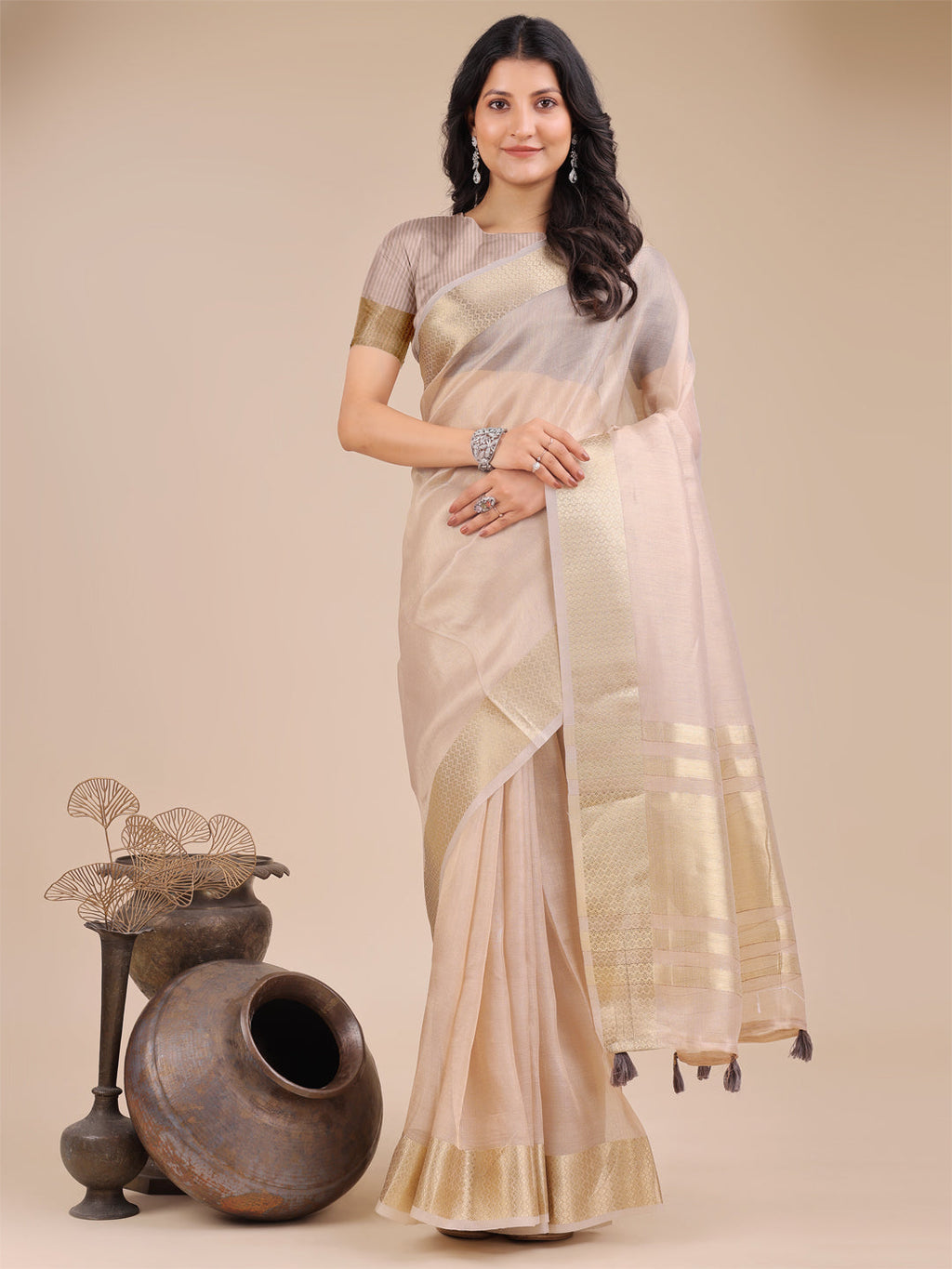 Light pink organza saree with shimmering woven zari accents and traditional decorative tassels