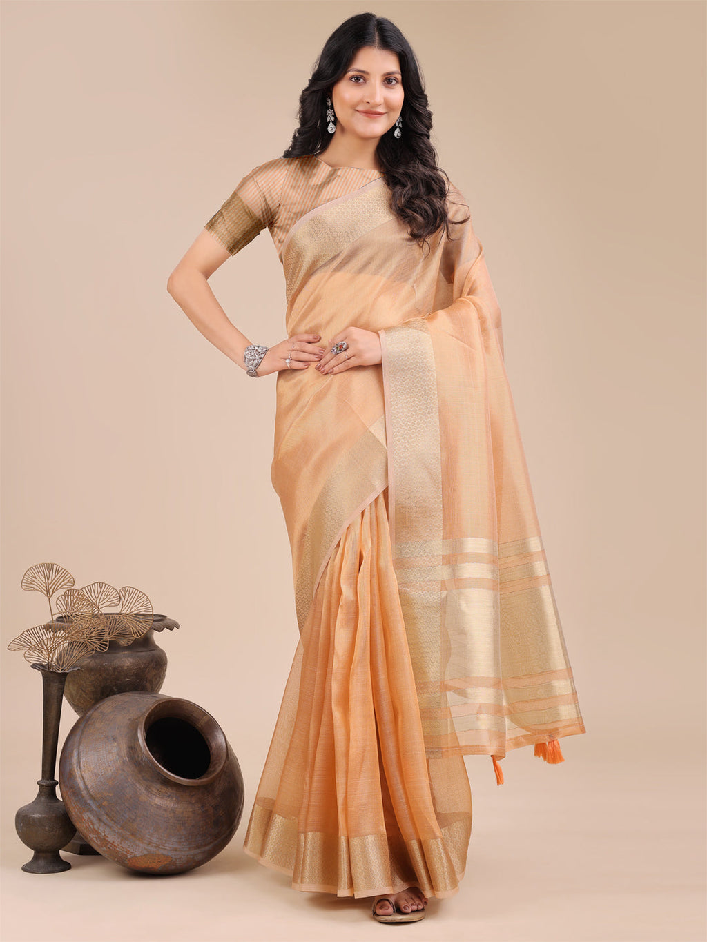 Vibrant orange organza saree featuring woven zari accents and traditional tassels
