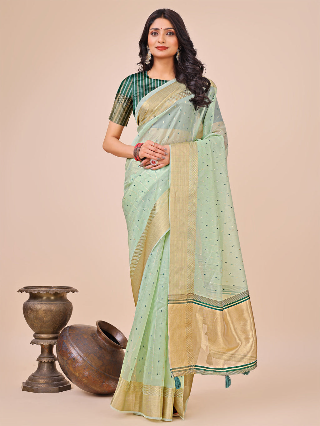 Olive green organza silk saree featuring a delicate golden border and woven accents